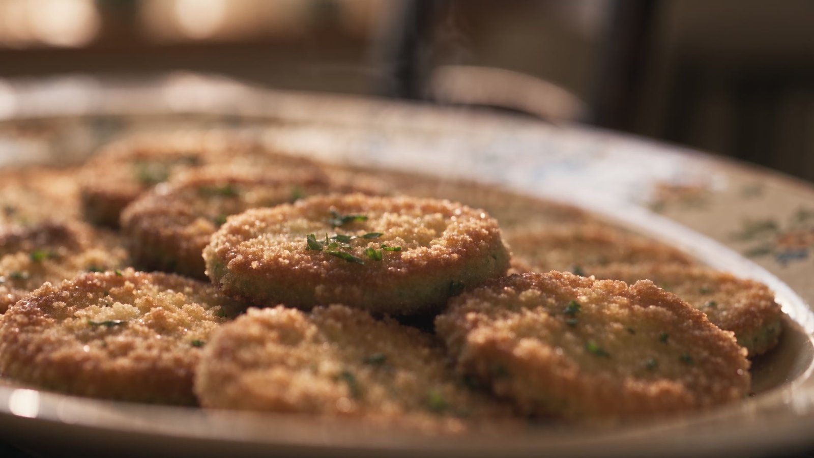 A platter of golden fried green tomato slices with Pecorino and parsley
